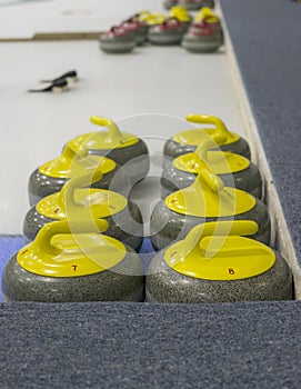 Yellow curling stones on ice