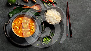 Yellow curry with chicken in bowl on dark background