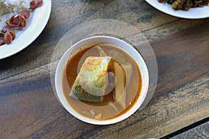 Yellow curry fish in bowl white thai southern style food, khaw khang-ti Thai word, Large pieces of fish soup in a cup is Thai As