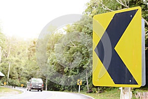 Yellow curve traffic sign on the road