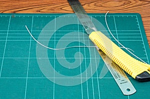 Yellow cutter and metal ruler.