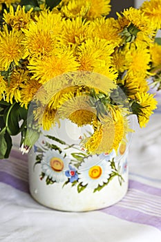 Yellow dandelions in a rustic vase