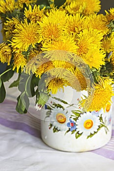 Yellow dandelions in a rustic vase