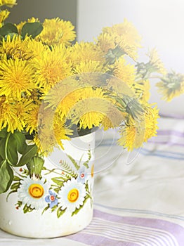 Yellow dandelions in a rustic vase