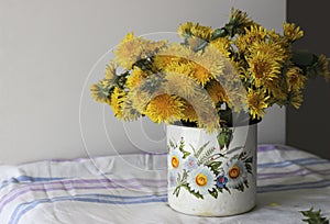 Yellow dandelions in a rustic vase