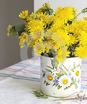 Yellow dandelions in a rustic vase