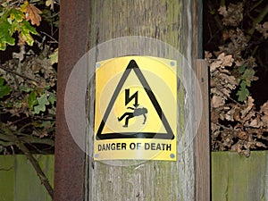 yellow danger of death safety sign outside pole electricity shoc