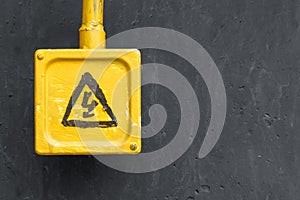 Yellow danger sign on the grey wall