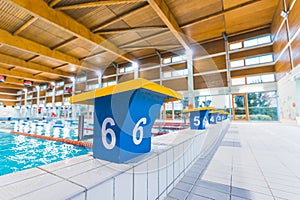 Yellow and dark blue swimming pool starter blocks with big white numbers on sides. Swimming pool equipment concept. High