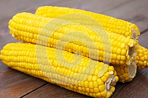 Yellow and delicious cobs on wooden table photo