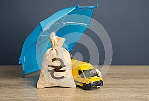 Yellow delivery van and ukrainian hryvnia money bag under an blue umbrella.