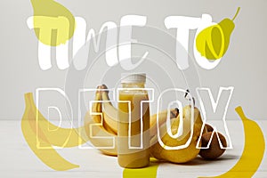 yellow detox smoothie in bottles with bananas, pears and kiwis on white background, time to