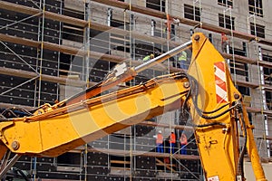 Yellow digger and construction workers