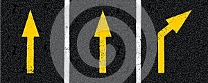 Yellow directional arrow signs on tarmac road top view