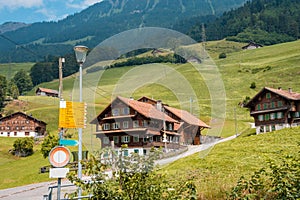 Yellow directional road signs. Wooden house in the background.