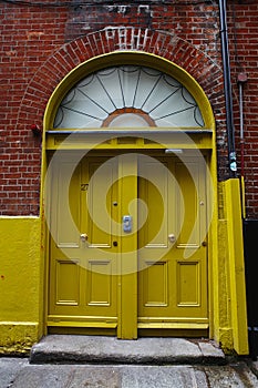 A yellow door in Dublin, Ireland. Arched Georgian door house front