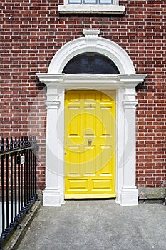 A yellow door in Dublin, Ireland. Arched Georgian door house front