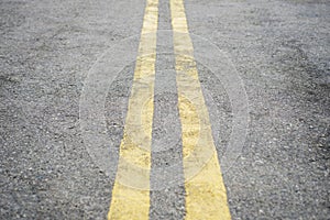 Yellow double solid line. Road markings on asphalt on the street. Highway surface with double yellow lines