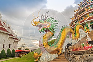 Yellow dragon head at Wat Huay Pla Kang, bublic Chinese temple in Chiang Rai Province, Thailand with dramatic blue sky background