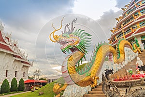 Yellow dragon head at Wat Huay Pla Kang, bublic Chinese temple in Chiang Rai Province, Thailand with dramatic blue sky background