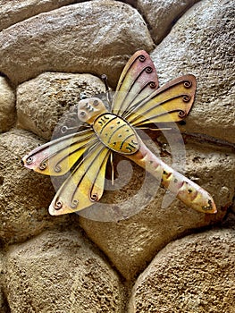 Yellow dragonfly hairclip, with rocks background