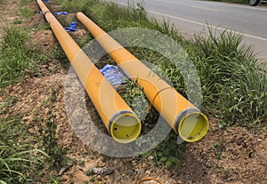 Yellow drainage pipe row near the road at Construction Site .Concrete stacked sewage water system aligned on site.