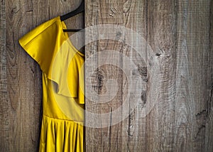 A yellow dress hangs on the background of the wardrobe