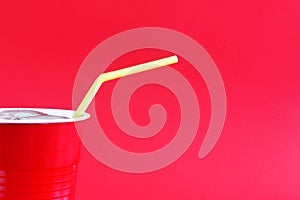 Yellow drinking straw in red cup