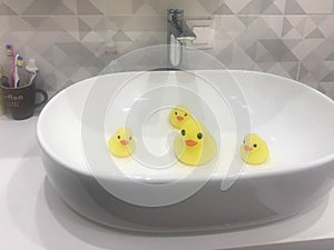 The yellow duck family swims in the sink due to pollution