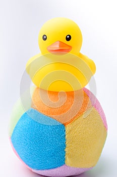 Yellow duck toy on toy soccer ball with white background