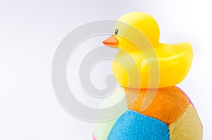 Yellow duck toy on toy soccer ball with white background