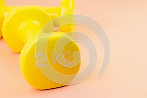Yellow dumbbells on pink background