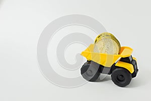 The yellow dump truck toy isolated bitcoin concept on white ba