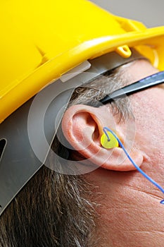 Yellow earplug into the ear close up