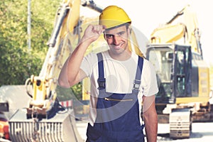 Yellow earthmover with handsome latin american construction work