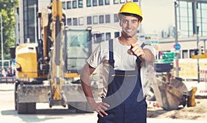 Yellow earthmover with pointing latin american construction work