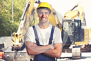 Yellow earthmover with strong latin american construction worker