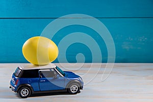 Easter egg in toy car on a blue background photo