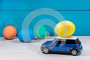 Easter egg in toy car on a blue background