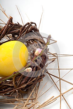 Yellow Easter egg in a wicker wreath