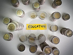 Yellow education paper and coins pile, Saving money for future plan and retirement fund concept