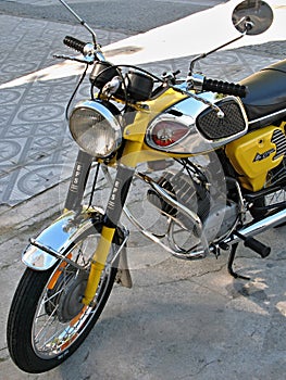 Yellow EFS motorcycle parked on a tiled sidewalk
