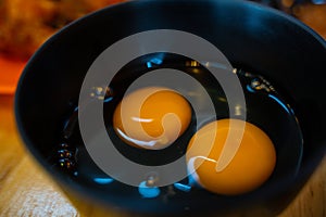 Yellow egg white and yolk baking ingredient in a black bowl