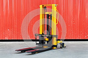 Yellow electric forklift pallet stacker crane in the warehouse front photo