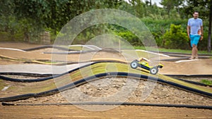 Yellow electric RC buggy racing on an offroad track