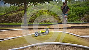 Yellow electric RC buggy racing on an offroad track