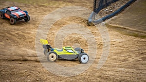 Yellow electric RC buggy racing on an offroad outdoor track