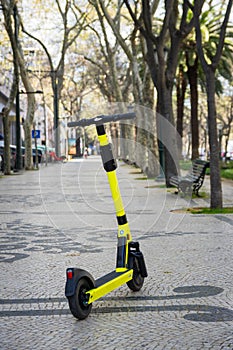 Yellow electric scooter for rent on the street