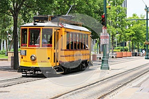 A yellow electric trolley on Main Street in downtown Memphis, Tennessee in summer