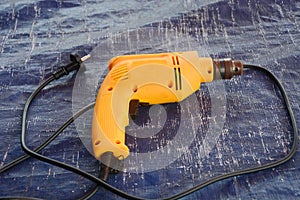 A yellow electrical drill with black cable.
